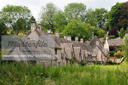 Célèbre ligne Arlington des cottages en pierre du XVIIe siècle avec pente raide toits, Bibury, Cotswolds, Gloucestershire, Royaume-Uni