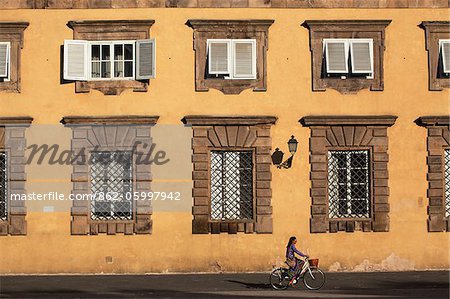 Italien, Toskana, Lucca. Menschen, die Radfahren in einer der Stadtplätze in der Altstadt