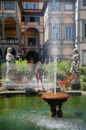 Italy, Tuscany, Lucca; A tourist enjoying the scenery of the gardens at Villa Pfanner.