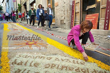 Italien, Umbrien, Perugia Bezirk, Spello, Frau setzt letzten Blütenblätter für die Infiorata