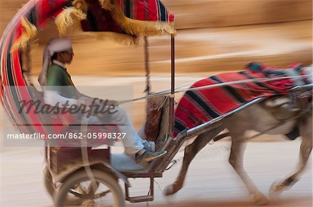 Pferd gezeichneten Wagen Reisen durch den Siq, eine enge Schlucht Passage führt zu der Treasuary, Petra