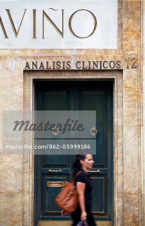Spain, Andalusia, Seville; Young woman walking in the city centre