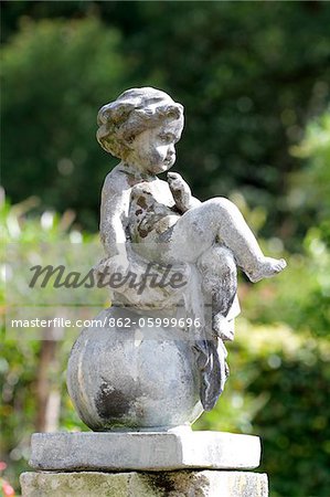 Detail of a stone cherub in the walled garden at the National Trust's Colby Woodland Garden, near Amroth, Pembrokeshire, Wales