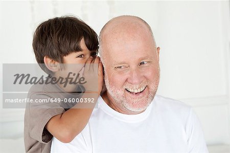 Boy whispering in fathers ear