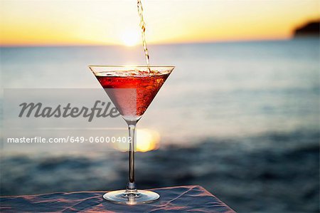 Cocktail pouring in glass outdoors