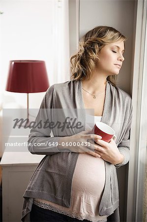 Pregnant woman having cup of coffee