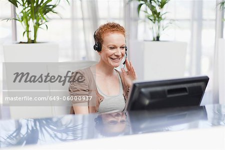 Receptionist wearing headset at desk