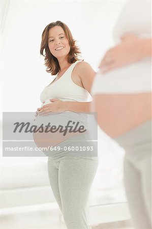 Ventre de femme enceinte admiratif de femme