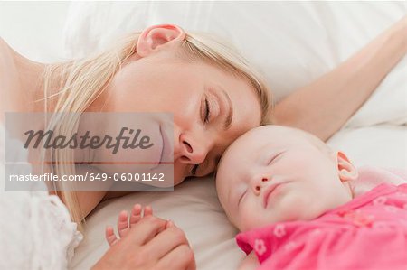 Mutter und Baby schläft auf dem Bett