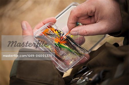 Man pulling fishing tackle from box