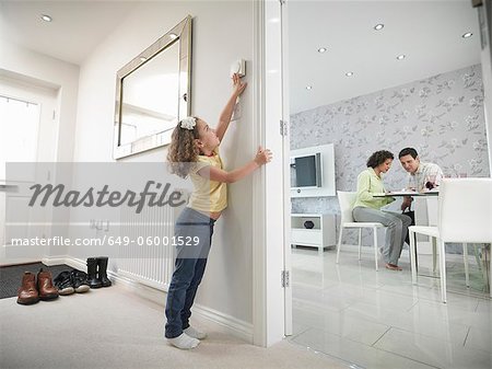 Girl reaching for thermostat