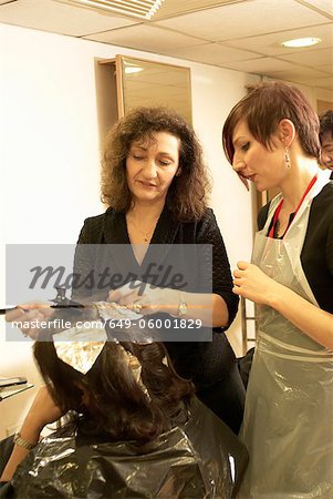 Hair stylist teaching student in salon