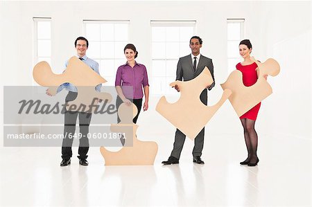 Business people holding puzzle pieces