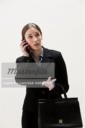 Portrait of young businesswoman using cellphone, studio shot