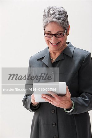 Mature femme d'affaires à l'aide de la tablette numérique, studio shot