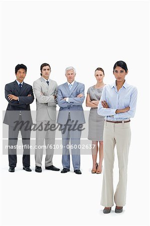 Équipe de graves affaires multiculturelles avec leurs bras plié avec une femme en premier plan sur fond blanc