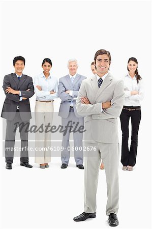 Smiling multicultural business team with their arms folded focus on a man in foreground
