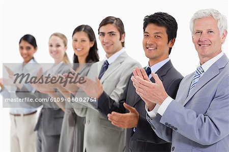 Close-up of multicultural business people applauding against white background