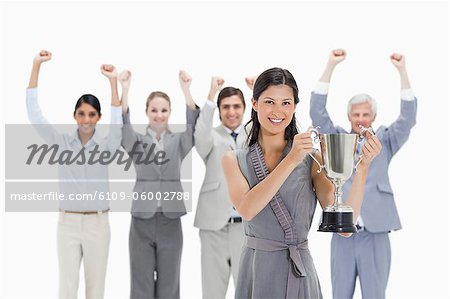 Close-up of a woman holding a cup with a business team raising their arms against white background