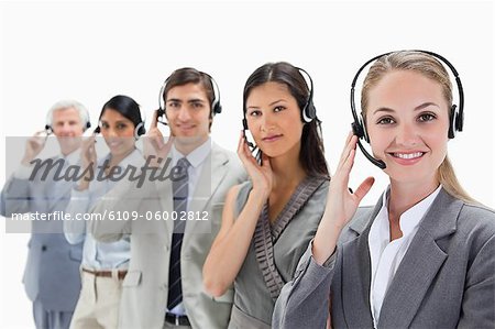 Professionals listening and smiling with headsets against white background