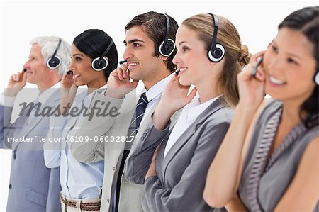 Smiling professionals listening wearing a headsets against white background