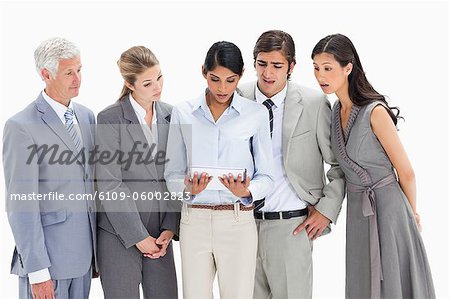 Close-up of surprised business people watching a touchpad against white background