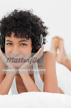 Gros plan d'une femme aux cheveux crépuse, écouter de la musique avec le casque