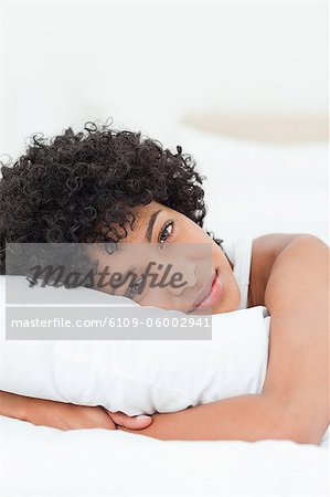 Porträt einer sexy Frau umarmt ihr Kissen vor weißem Hintergrund