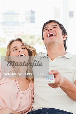 A close up shot of a man and woman laughing together at a television programme.