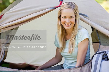 A woman inside of the tent while she looks straight ahead at the camera