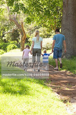 Deux enfants marchant avec leurs parents dans le parc