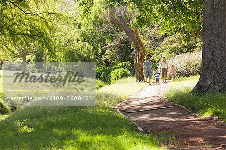 A family walking down a path together almost out of the cameras sight