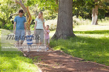 Une famille s'en rapprocher vers la caméra dans le parc