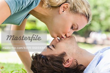 Jeune couple baiser sur la pelouse