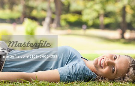 Seitenansicht einer jungen Frau, die auf dem Rasen liegend