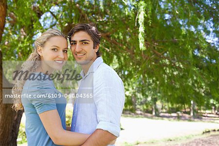 Side view of an embracing young couple in the park