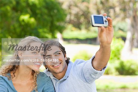 Young couple in the park taking pictures of themselves