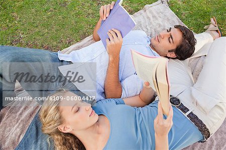 Jeune couple dans le parc, lire leurs livres