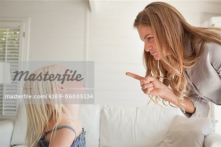 Daughter looks up at her mother as she gets punished