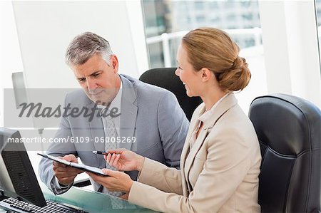 Geschäftsleute arbeiten in einem hellen Büro mit Witwen im Hintergrund