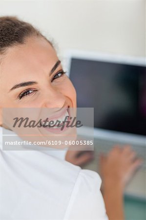 Porträt einer gebräunten Frau mit einem Laptop mit schwarzer Bildschirm in einem hellen Büro