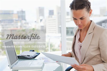 Businesswoman reading files in a bright office