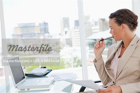 Geschäftsfrau mit einem Zopf außerhalb von ihrem hellen Büro suchen