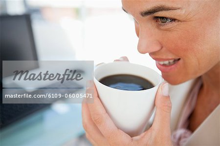 Nahaufnahme der geschäftsfrau mit einem Kaffee vor ihrem computer