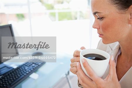 Nahaufnahme eines Mitarbeiters halten einen Kaffee vor ihrem computer