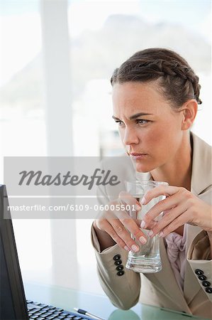 Businesswoman holding a glass of water in a bright office