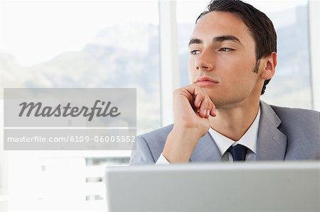 Businessman looking outside in a bright office