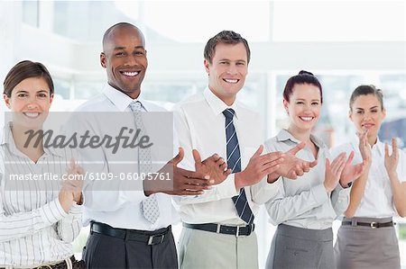 Clapping young salesteam standing in a line