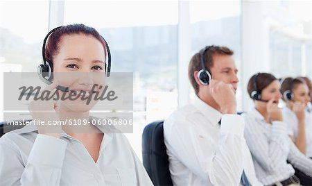 Lächelnde junge Telefon Hilfe Rezeption Mitarbeiter am Arbeitsplatz