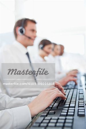 Female hands using a keyword with call center agents in the background